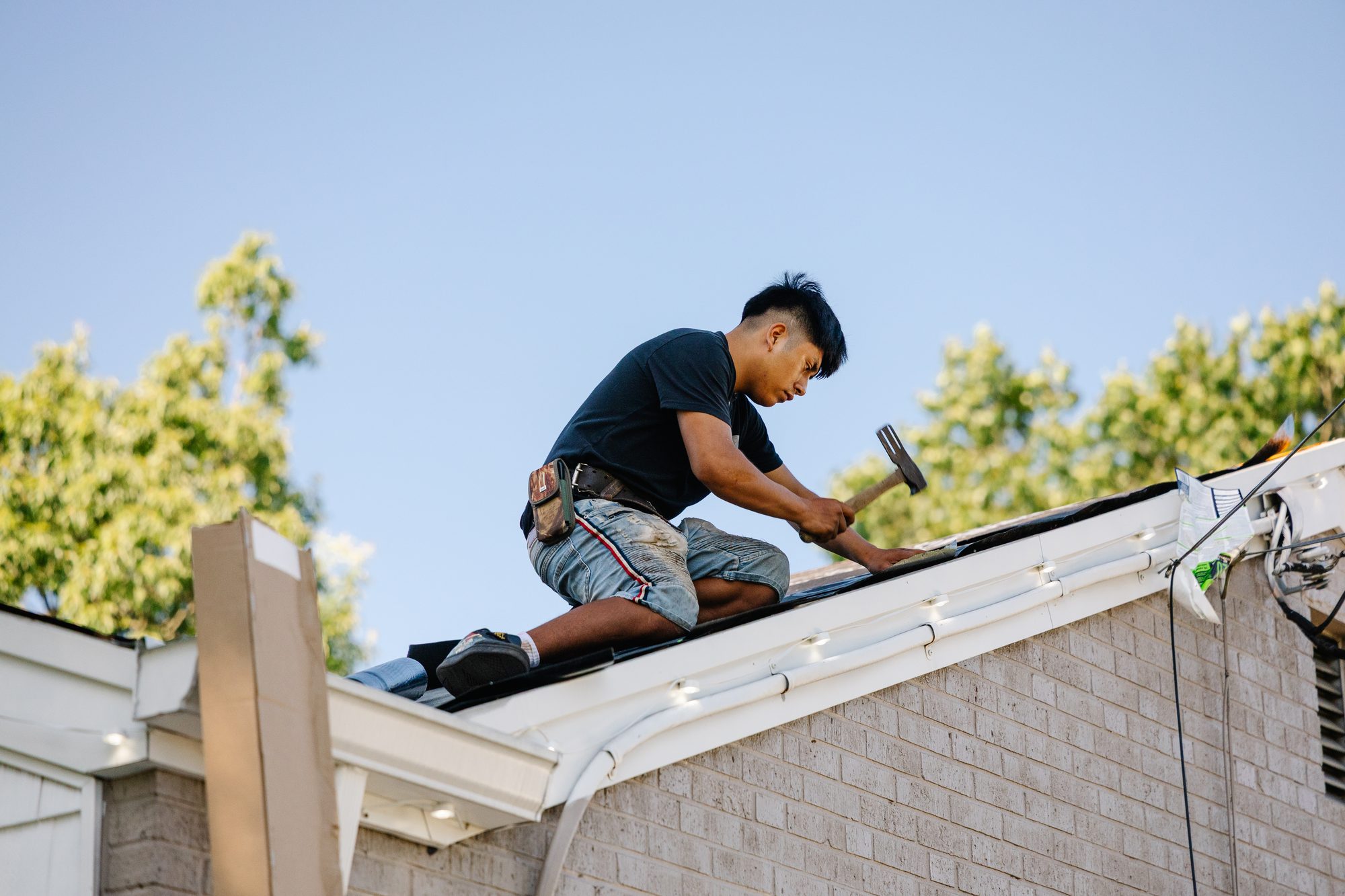 Roofer installing shingles